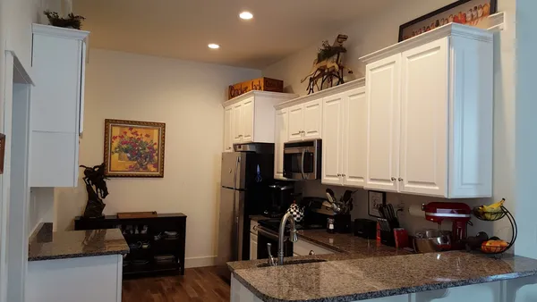 a kitchen with stainless steel appliances granite countertop a sink and a refrigerator