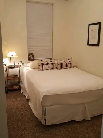 a bedroom with a bed and a flat tv screen on dresser