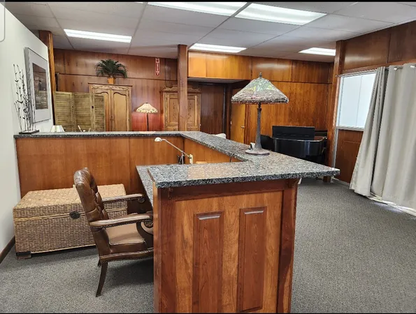 a living room with a table chairs and a refrigerator