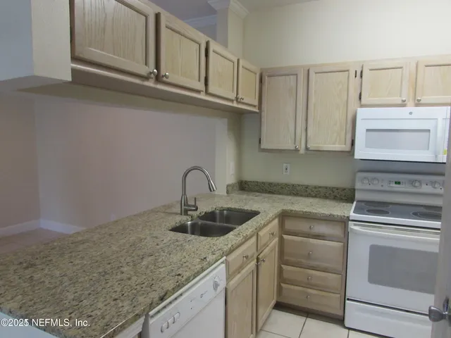a kitchen with granite countertop cabinets stainless steel appliances and a sink
