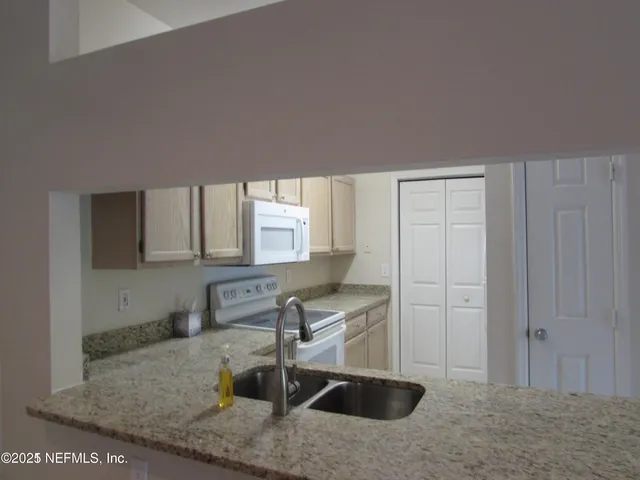 a kitchen with granite countertop a sink a window and a granite counter tops