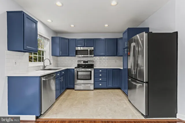 a kitchen with stainless steel appliances granite countertop a refrigerator stove and sink