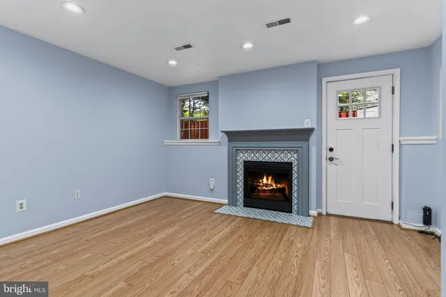 a view of an empty room with a window and fireplace