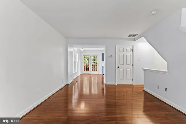 a view of empty room with wooden floor and window