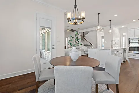 a dining room with furniture a chandelier and wooden floor