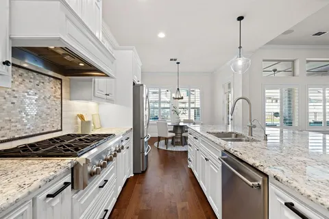 a kitchen with stove a sink and cabinets