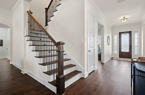 a view of a hallway with wooden floor and entryway