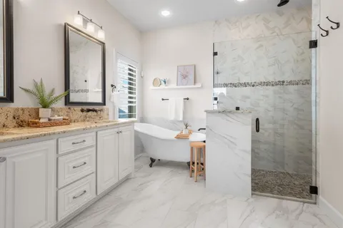 a spacious bathroom with double vanity sink a mirror and a shower