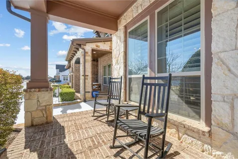 a view of two chairs and a table in the balcony