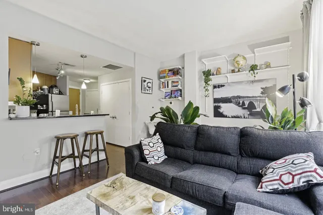 a living room with furniture and a dining table with wooden floor