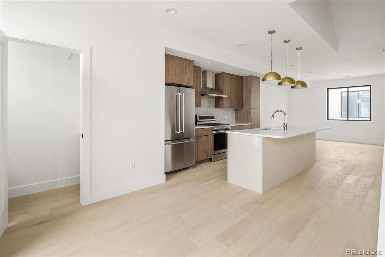 4517 Tennyson Street Denver, CO 80212 - Photo 16 of 34 a kitchen with stainless steel appliances a refrigerator a sink a stove a microwave a dining table and chairs