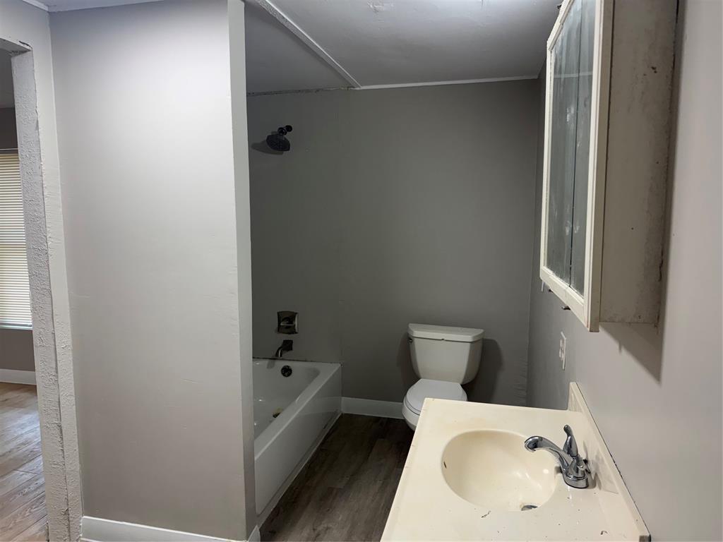 117 Aztec Way West Tawakoni, TX 75474 - Photo 9 of 12 Bathroom featuring a white bathtub, toilet, and vanity with an integrated sink