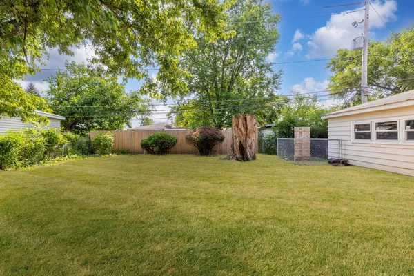 a backyard of a house with table and chairs