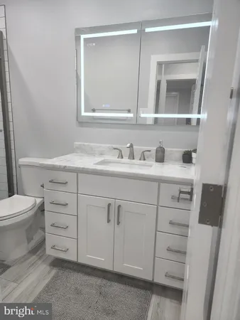 a bathroom with a toilet sink and mirror