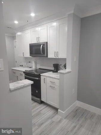 a kitchen with a sink a stove and cabinets