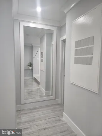 a view of a hallway with wooden floor and closet