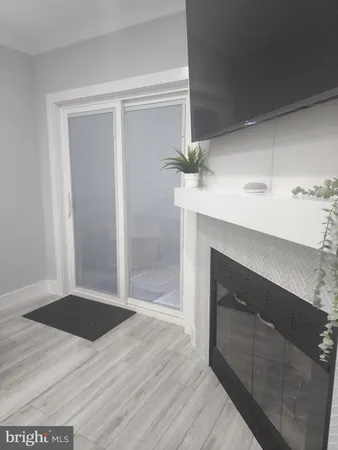 a view of empty room with wooden floor and fireplace