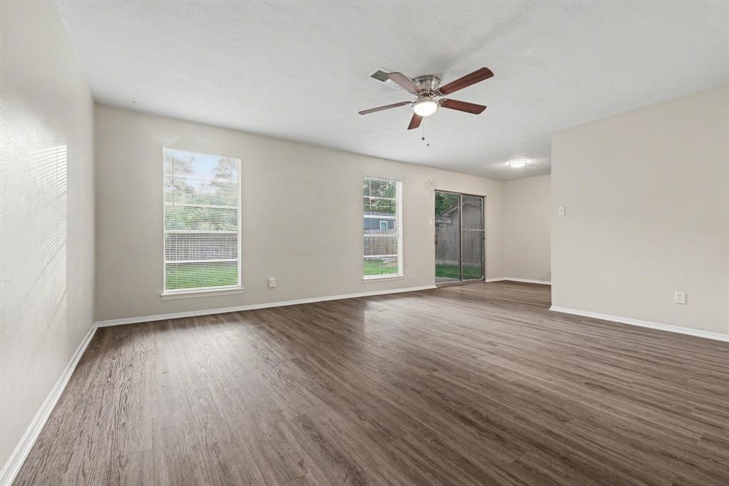1321 North 7th Street Conroe, TX 77301 - Photo 4 of 17 a view of an empty room with wooden floor and a window