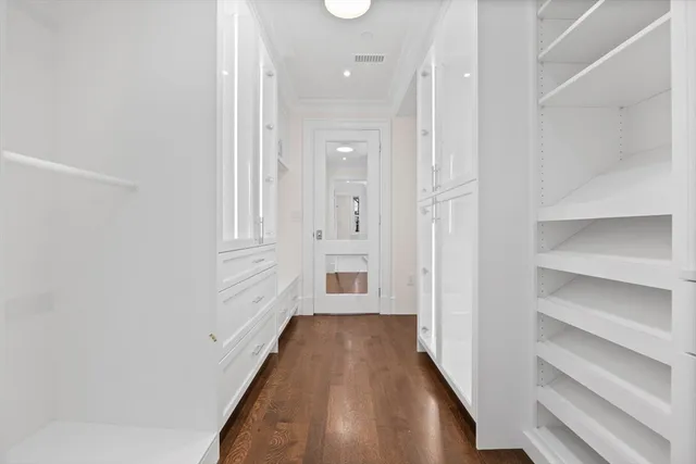 a view of a hallway with wooden floor and entryway