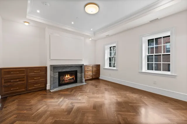 an empty room with windows and fireplace
