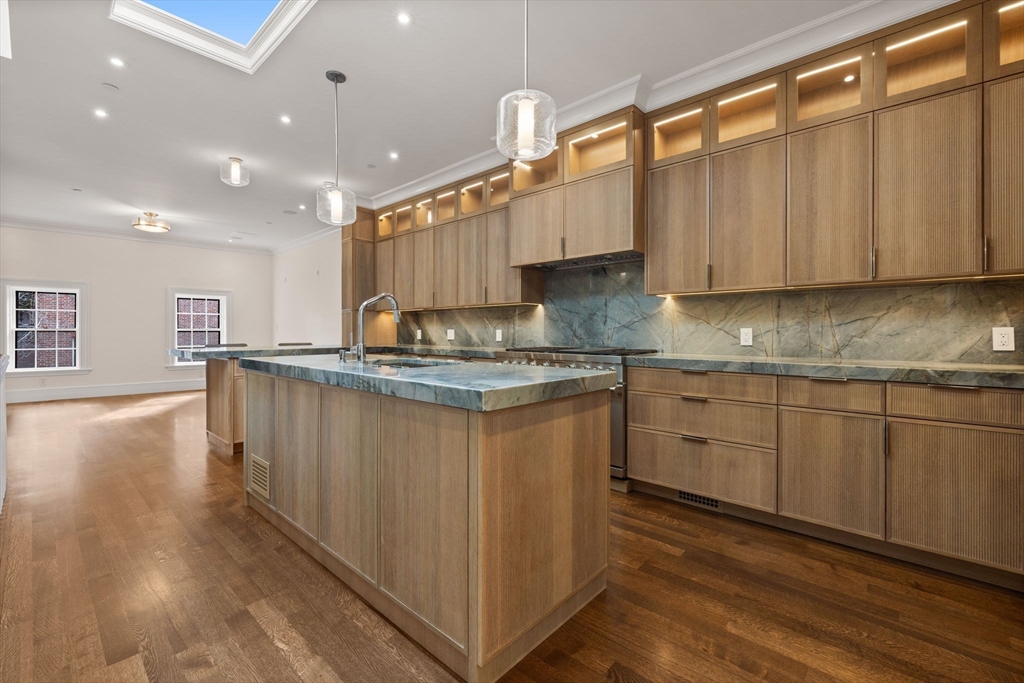2 Byron Street Boston, MA 02108 - Photo 2 of 30 a kitchen with kitchen island granite countertop a sink cabinets and wooden floor