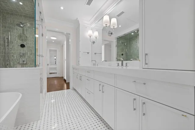 a spacious bathroom with a double vanity sink a large mirror and shower