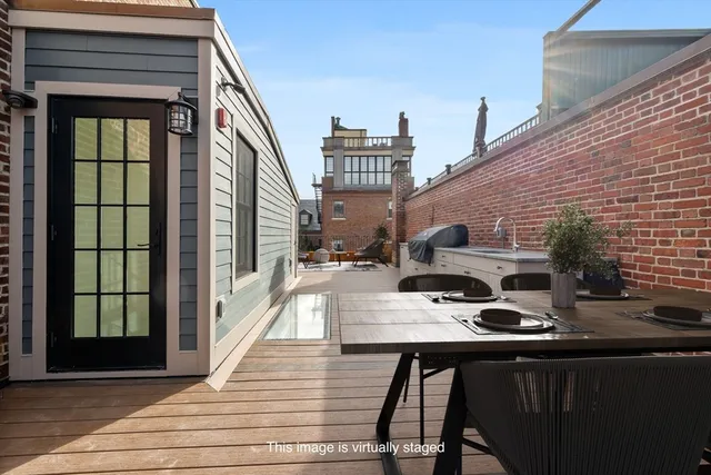 a view of a balcony with chairs and wooden floor
