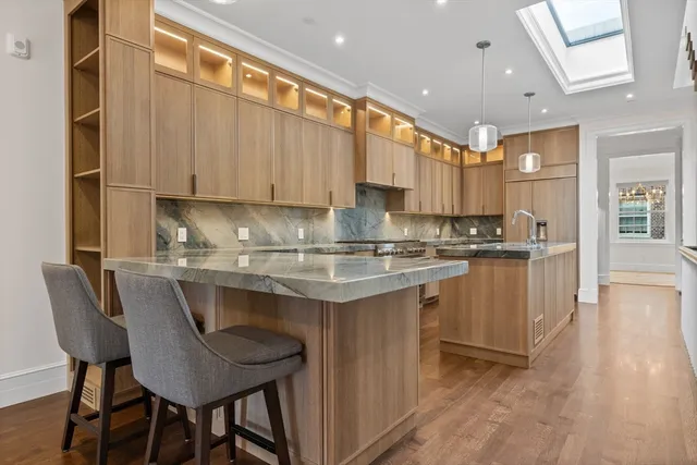 a kitchen with stainless steel appliances granite countertop a table chairs sink and cabinets