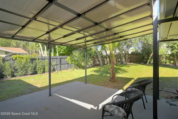 a view of a patio with table and chairs under an umbrella
