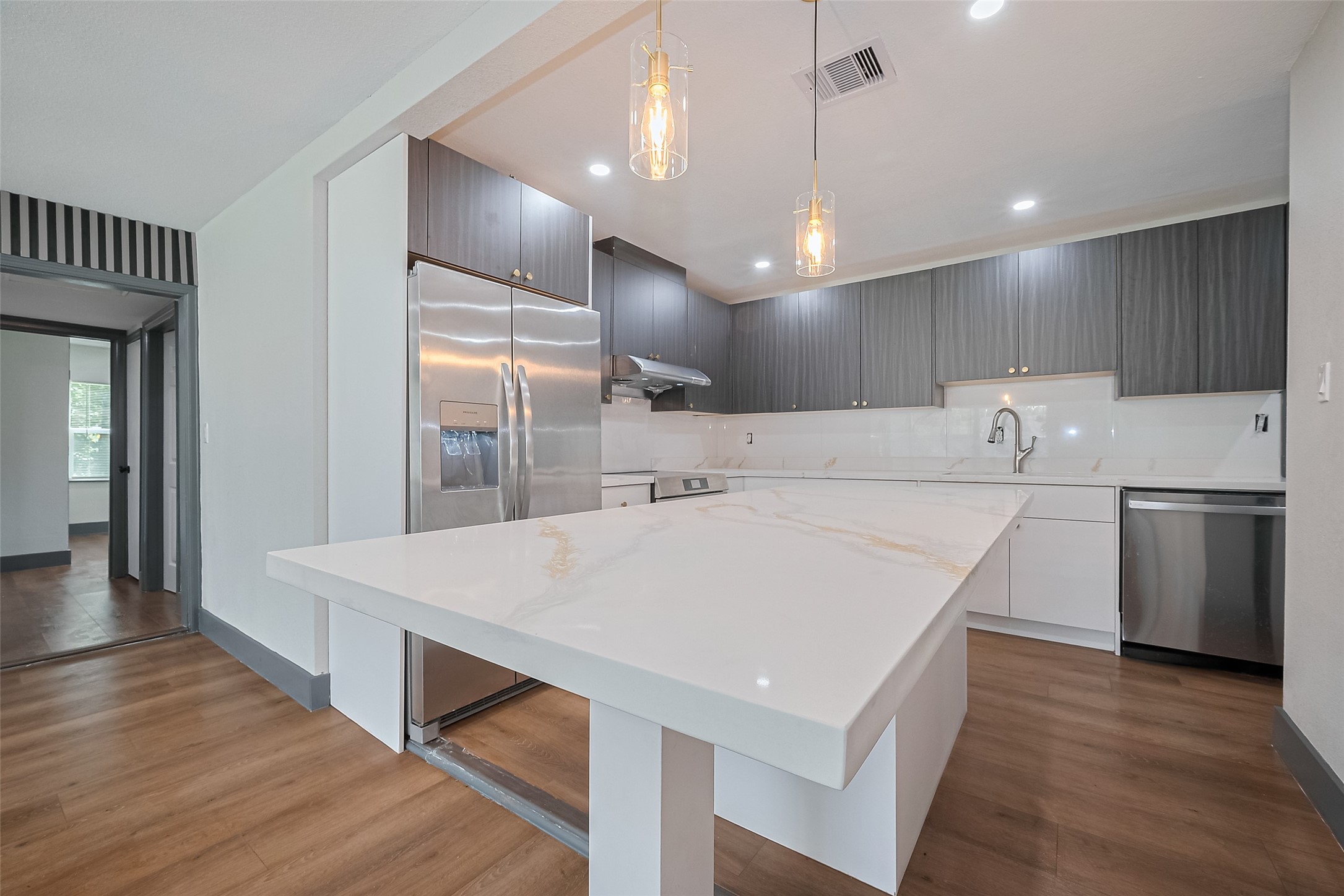 6058 Lyndhurst Drive Houston, TX 77033 - Photo 13 of 50 a large kitchen with kitchen island a stove a sink dishwasher and a refrigerator with wooden floor