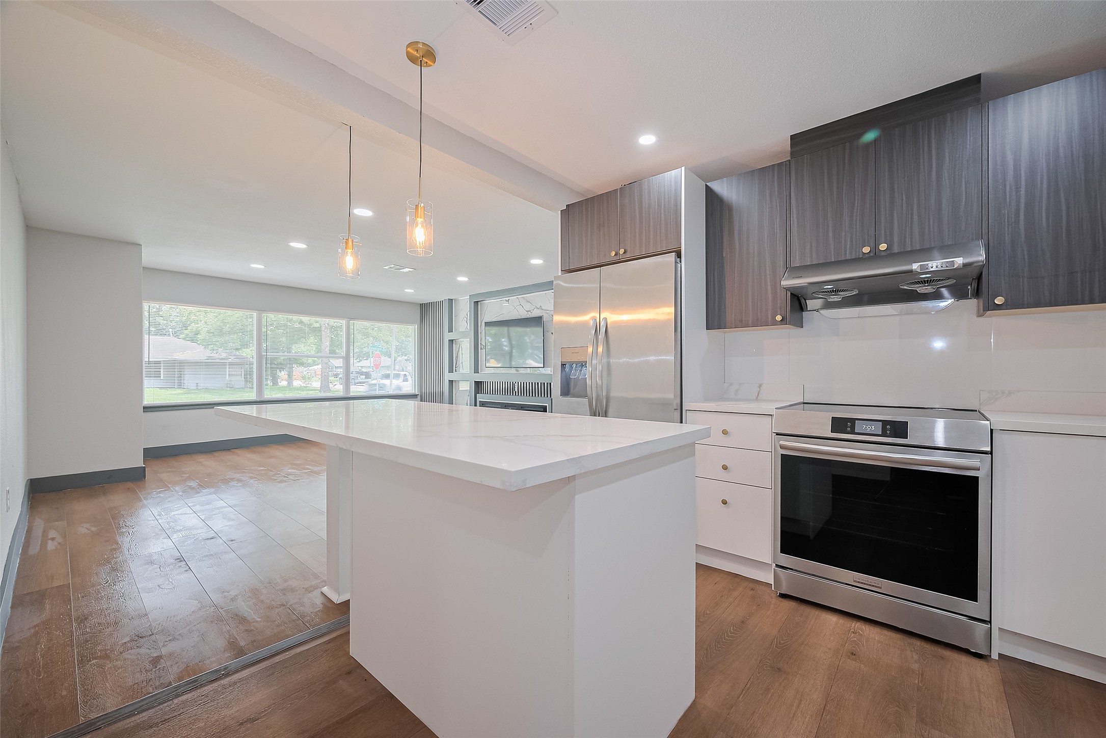 6058 Lyndhurst Drive Houston, TX 77033 - Photo 21 of 50 a kitchen with kitchen island a stove a sink a center island and wooden floor