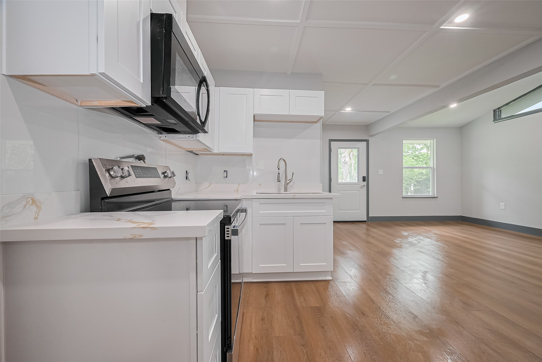 6058 Lyndhurst Drive Houston, TX 77033 - Photo 22 of 50 a kitchen with stainless steel appliances granite countertop a sink a stove a microwave a refrigerator white cabinets and wooden floor