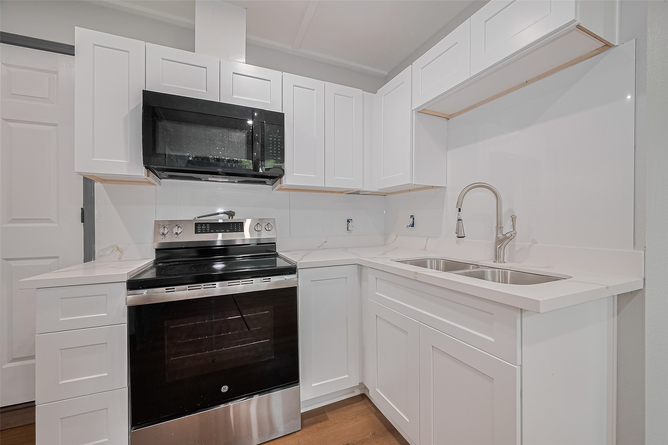 6058 Lyndhurst Drive Houston, TX 77033 - Photo 23 of 50 a kitchen with stainless steel appliances a stove a microwave a sink and cabinets