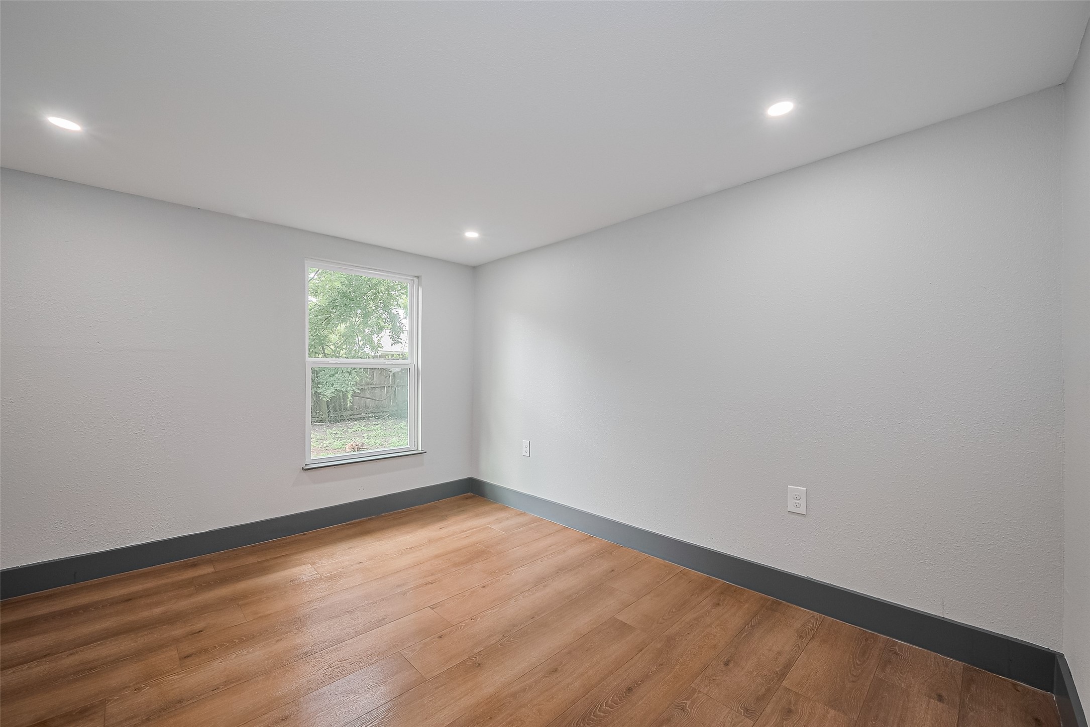 6058 Lyndhurst Drive Houston, TX 77033 - Photo 28 of 50 an empty room with wooden floor and windows