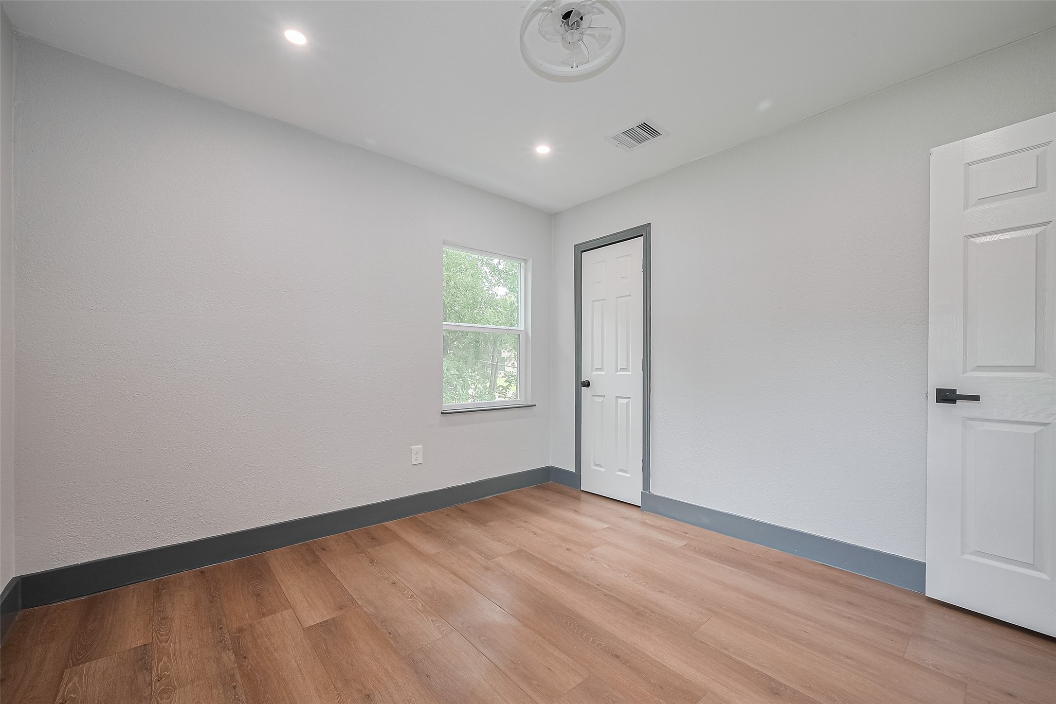 6058 Lyndhurst Drive Houston, TX 77033 - Photo 38 of 50 a view of empty room with wooden floor and fan