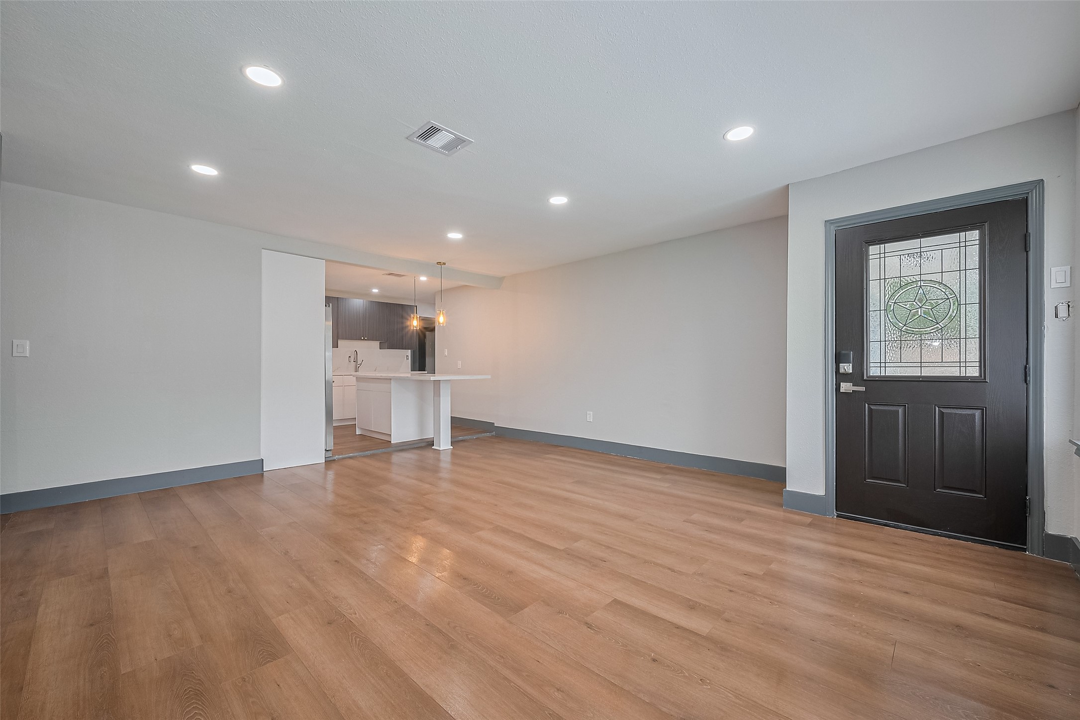 6058 Lyndhurst Drive Houston, TX 77033 - Photo 5 of 50 a view of empty room with wooden floor and window