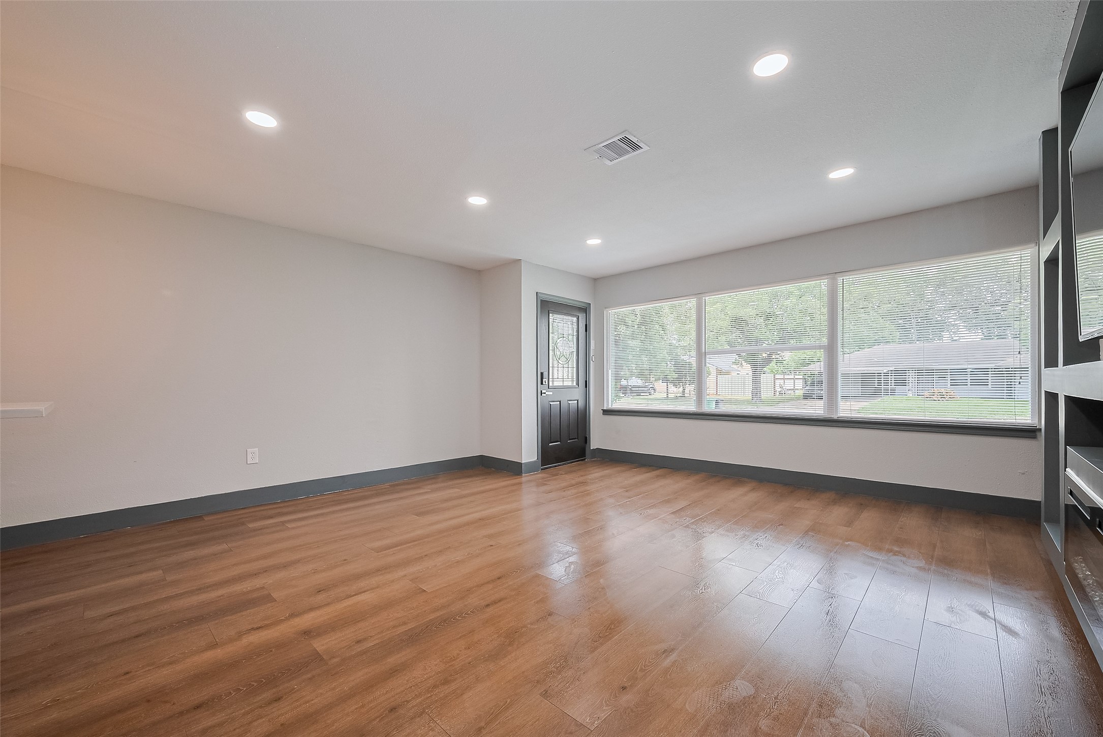 6058 Lyndhurst Drive Houston, TX 77033 - Photo 6 of 50 a view of an empty room with wooden floor and a window