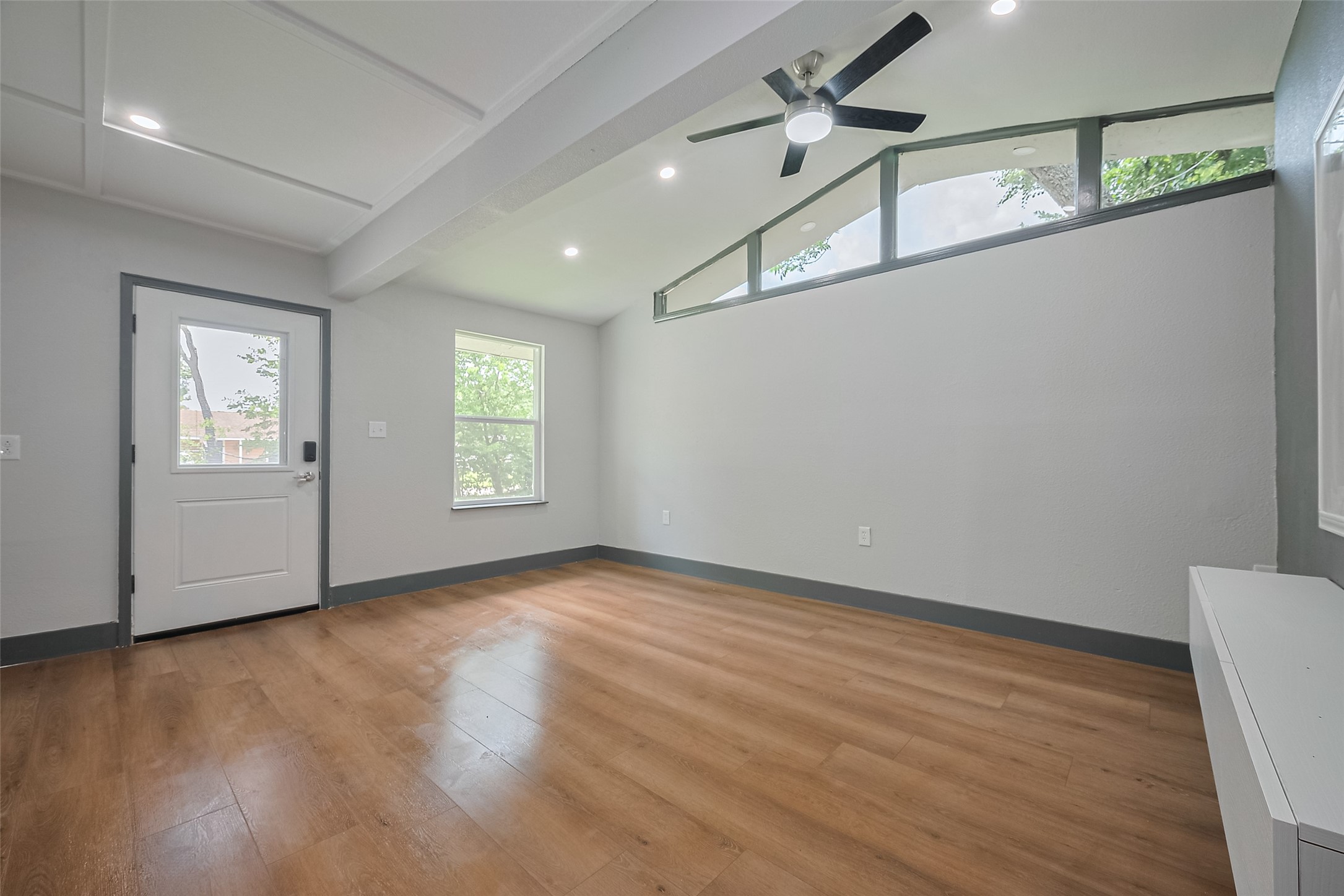 6058 Lyndhurst Drive Houston, TX 77033 - Photo 9 of 50 an empty room with wooden floor chandelier fan and windows
