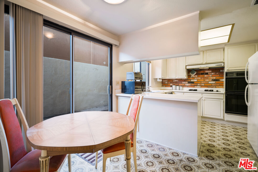 1445 Valley View Road, Unit 2 Glendale, CA 91202 - Photo 17 of 36 a kitchen with stainless steel appliances a dining table chairs and refrigerator