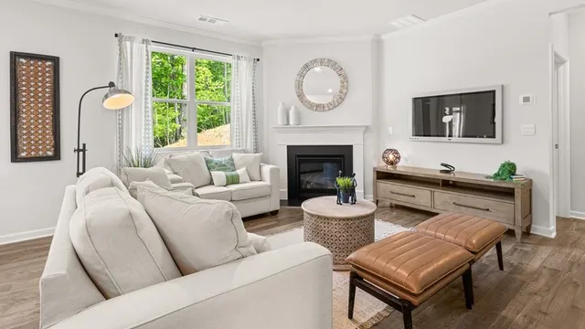 a living room with furniture a fireplace and a large window