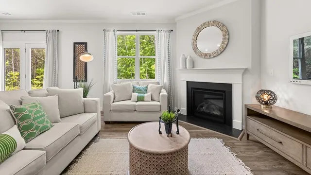 a living room with furniture a fireplace and a large window