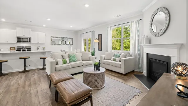 a living room with furniture a fireplace and a large window