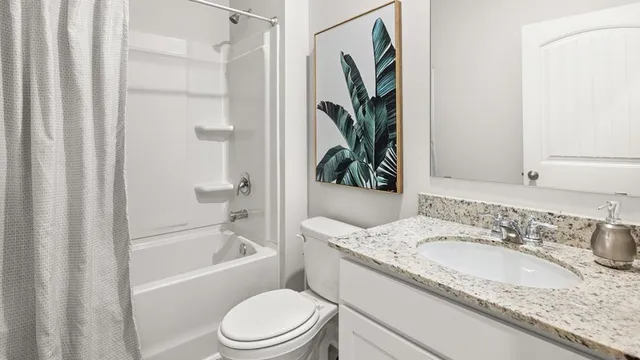 a bathroom with a granite countertop sink toilet and a bathtub