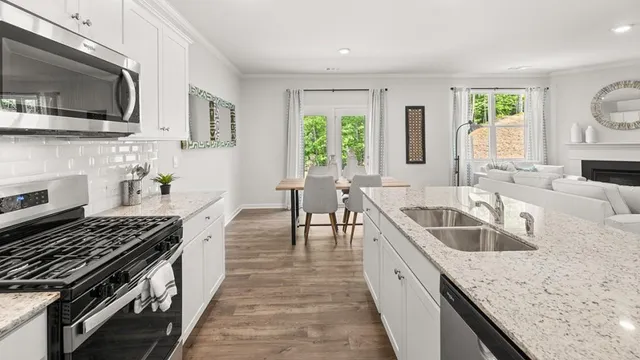 a kitchen with stainless steel appliances granite countertop a sink stove and cabinets