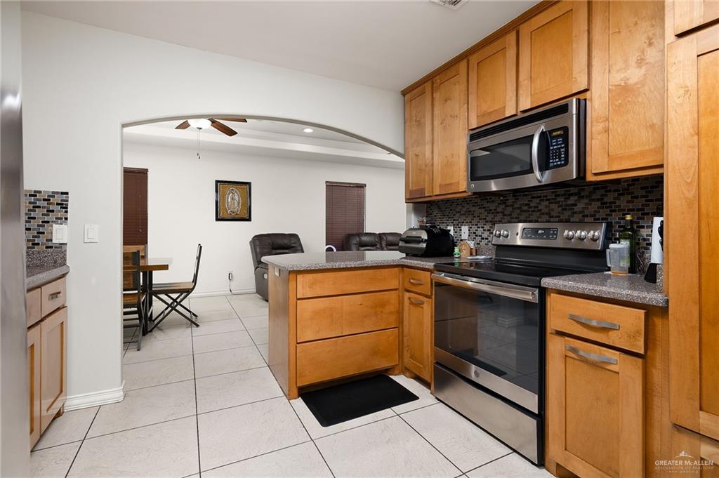 3609 Paseo Del Rey Edinburg, TX 78542 - Photo 8 of 20 a kitchen with stainless steel appliances granite countertop a stove a sink and a microwave