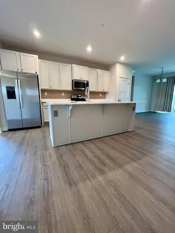 a kitchen with stainless steel appliances wooden floors and wooden cabinets