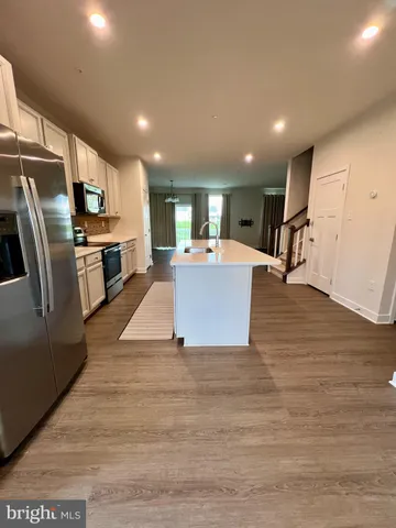 a view of kitchen with kitchen island microwave and refrigerator
