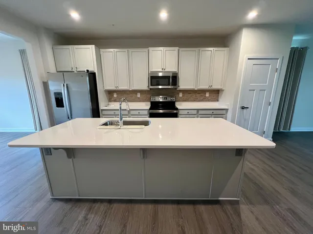 a kitchen with kitchen island a sink refrigerator and wooden cabinets