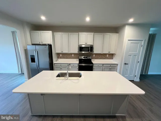 a kitchen with kitchen island a refrigerator sink and stove