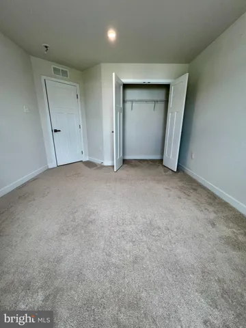 an empty room with closet and mirror